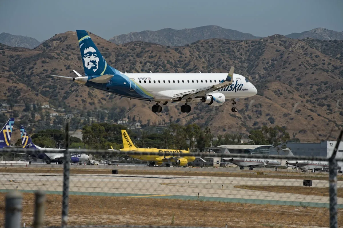 Burbank, USA Alaska airliner landing at Burbank airport, before the San Gabriel mountains and blue skies.