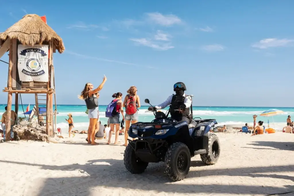 Tourists wave at Police on cancun beach