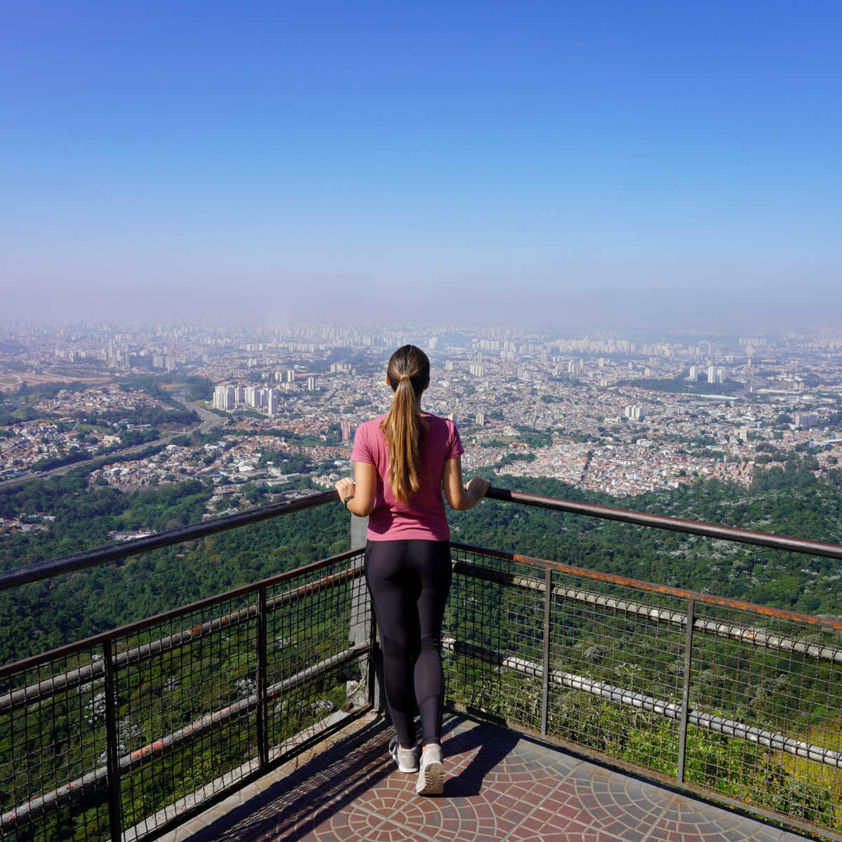 Young woman enjoying cityscape of Sao Paulo from Jaragua Peak