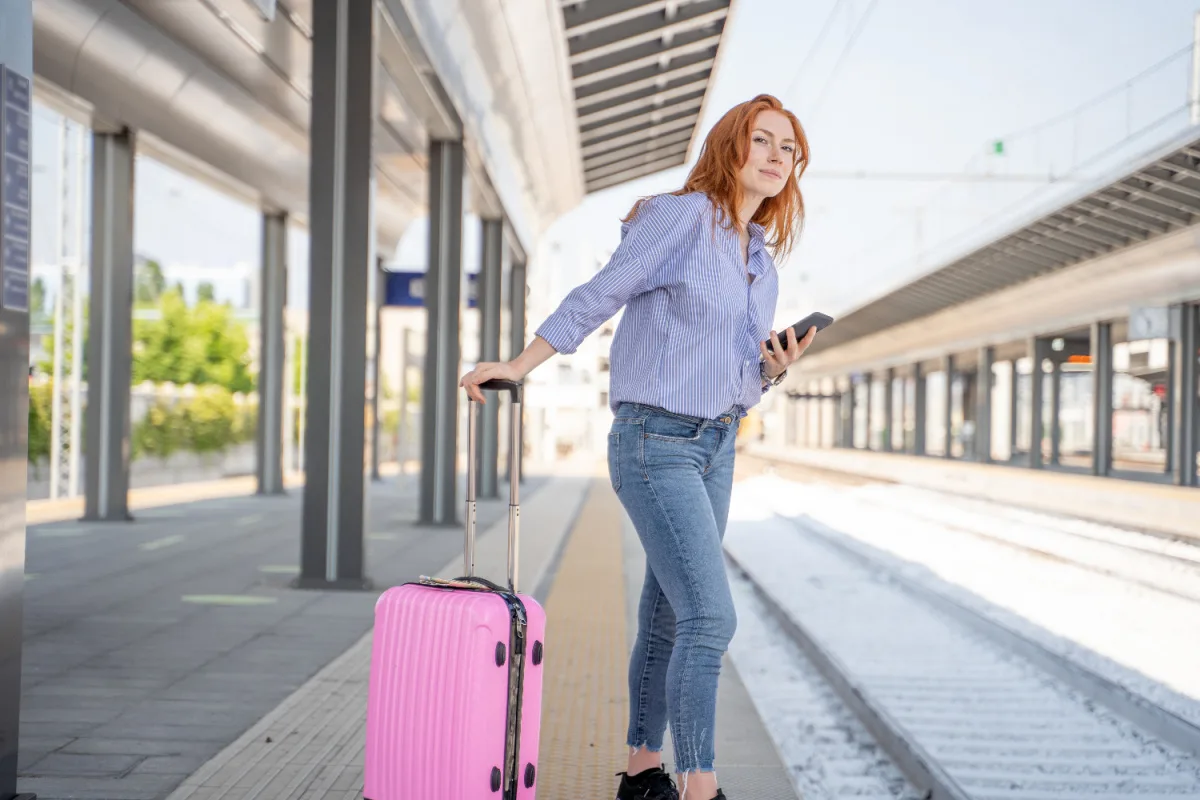 Woman with pink luggage waiting for train
