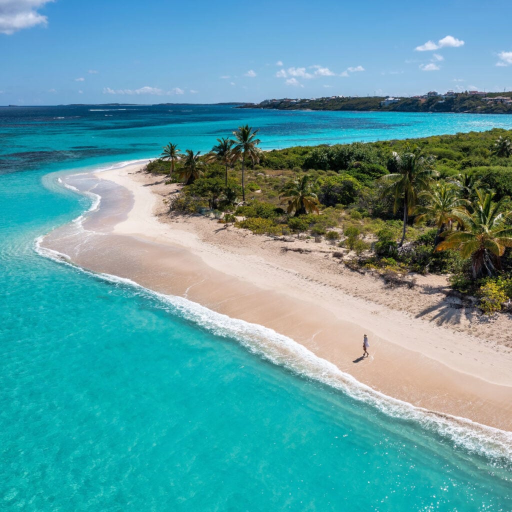 Lone beachgoer walking along shoreline in Anguilla