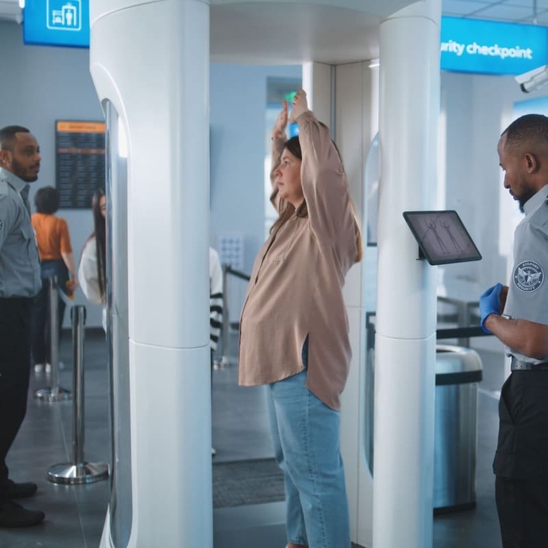A Woman Getting Checked At Security At An Airport