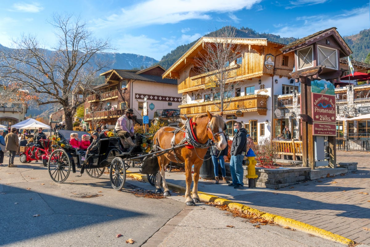 A horse carriage for hire with tourists in the colorful Bavarian themed village of Leavenworth.