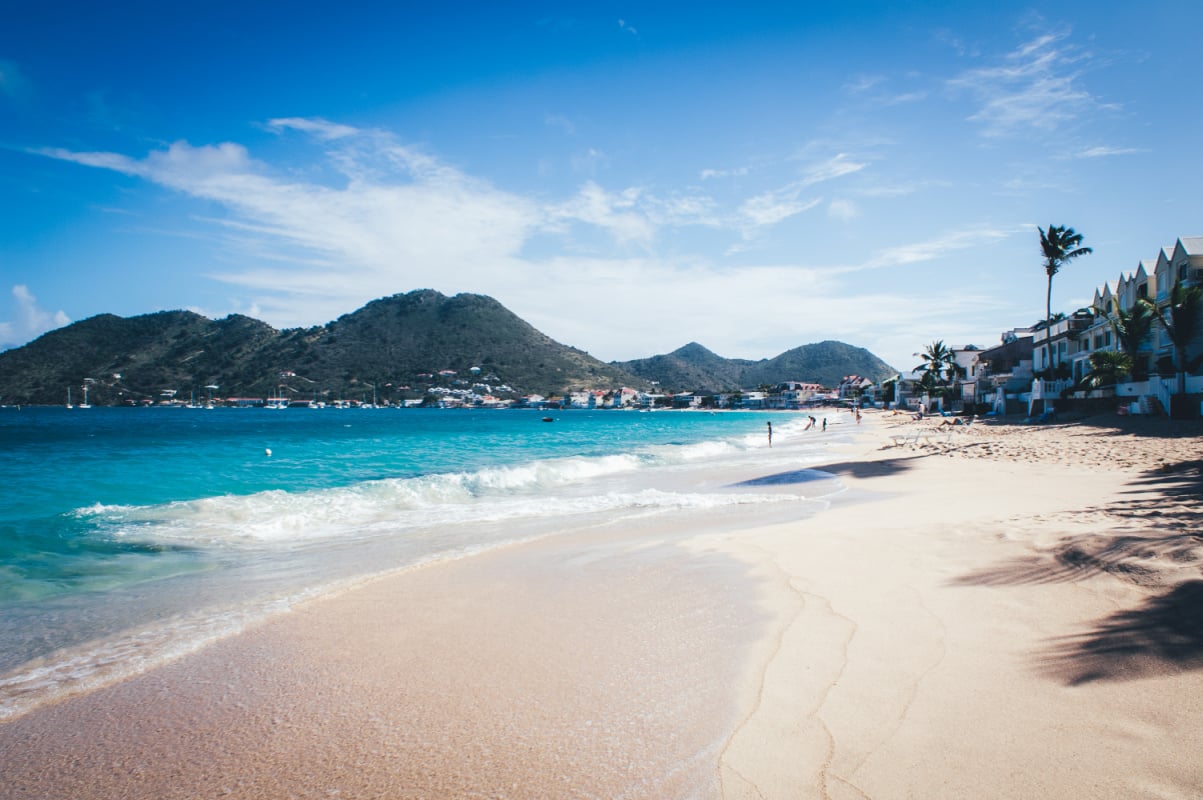 Grand-Case - Saint-Martin - Beach landscape with transparent blue sea and mountain in the background.