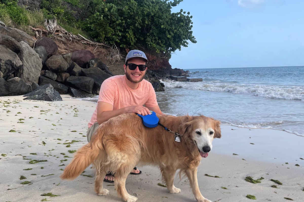 Managing Editor Tyler Fox with his Golden Retiever on BBC beach in Grenada on a walk