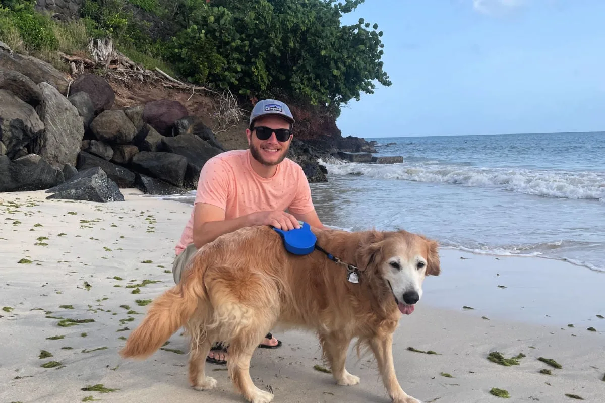 Managing Editor Tyler Fox with his Golden Retiever on BBC beach in Grenada on a walk