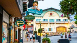 People enjoy a warm summer evening on the street in Leavenworth city center among Bavarian-style buildings and businesses