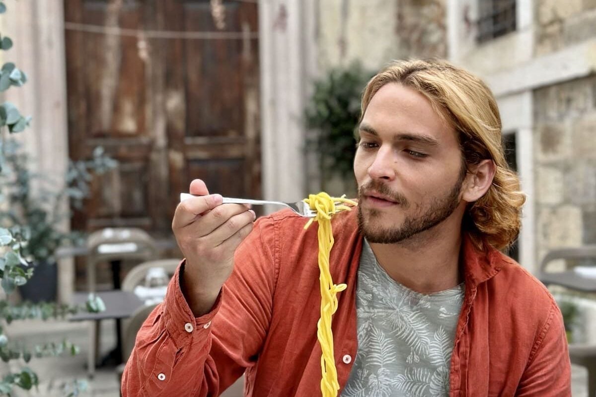 Young Tourist Eating Pasta In Bergamo, Italy