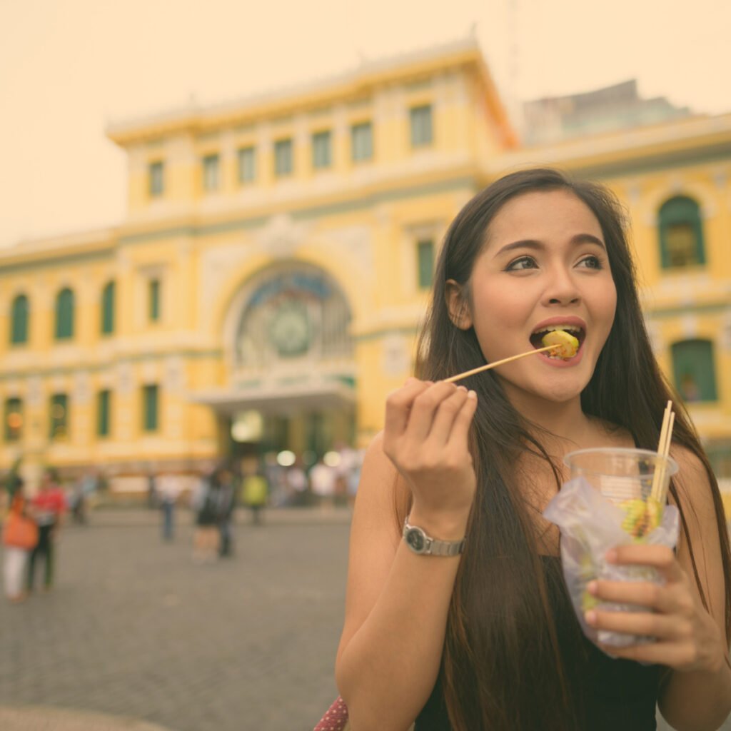Young woman eating Vietnamese street food