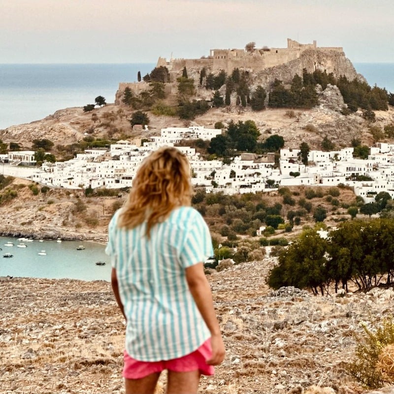 A Young Tourist Admiring A View Of Lindos, Rhodes, Greece