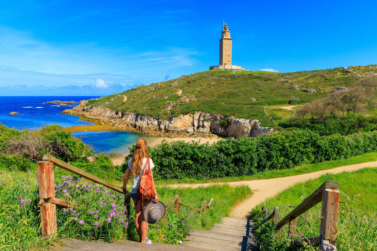 A Female Tourist Walking Towards The Tower Of Hercules, A Coruna, Galicia, Spain