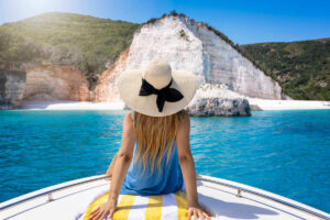 A Young Woman On A Boat Headed For Fteri Beach In Kefalonia, Greece