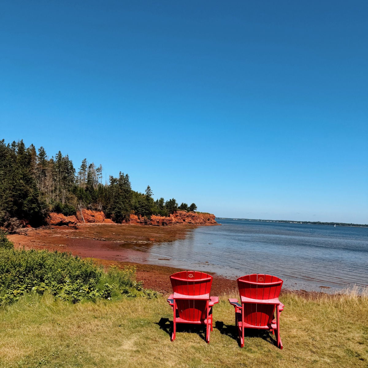 Two chairs on red-sand beach in PEI, Canada