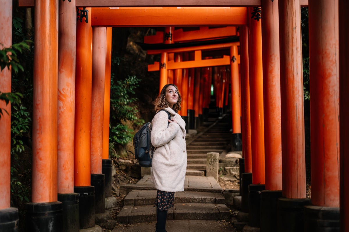 Woman exploring Fushimi Inari shrine torii gates in Kyoto, Japan