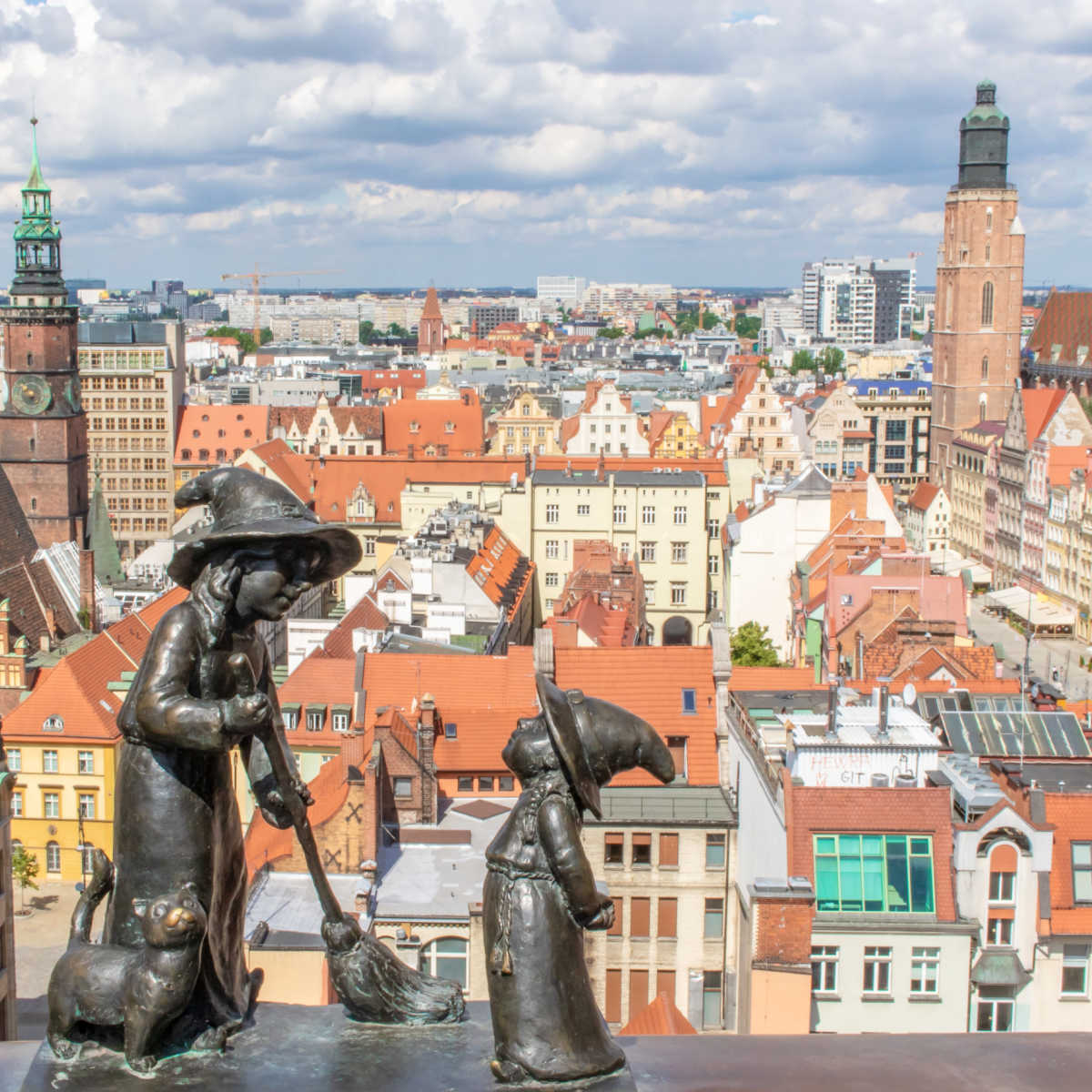 Bronze dwarf statues backed by Wroclaw, Poland cityscape