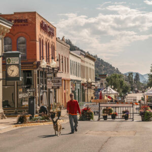 Man walking dog through Idaho Springs, CO