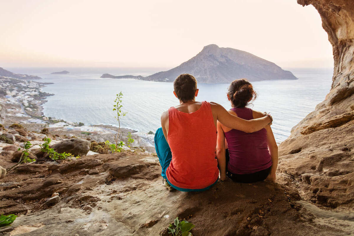 A Couple Admiring A View Of Telendos Island From Grande Grotta, Kalymnos, Greece