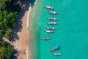 Banner Travel photo Thailand. Aerial view turquoise water, tropical beach Phuket with longtail boat.