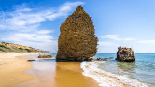 Wall of ruins on beach in Mazagon, Spain