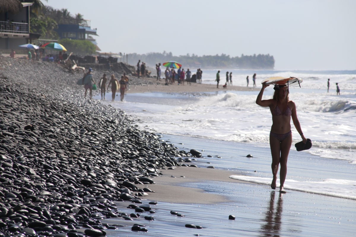 El Tunco, El Salvador - A young girl with a surfboard, capturing the laid-back surf culture and tropical vibe of El Tunco's Pacific coast.