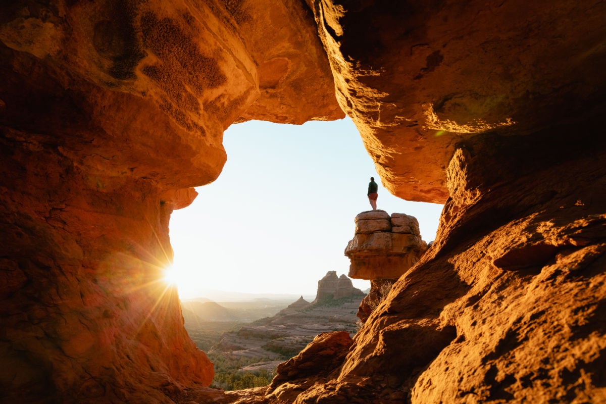 Woman stands at a dramatic viewpoint on Merry-go-round Rock in Sedona, AZ