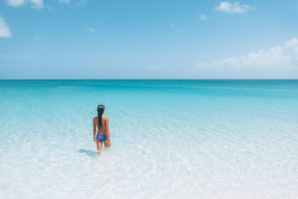 Woman stepping into ocean in South Caicos, Turks and Caicos