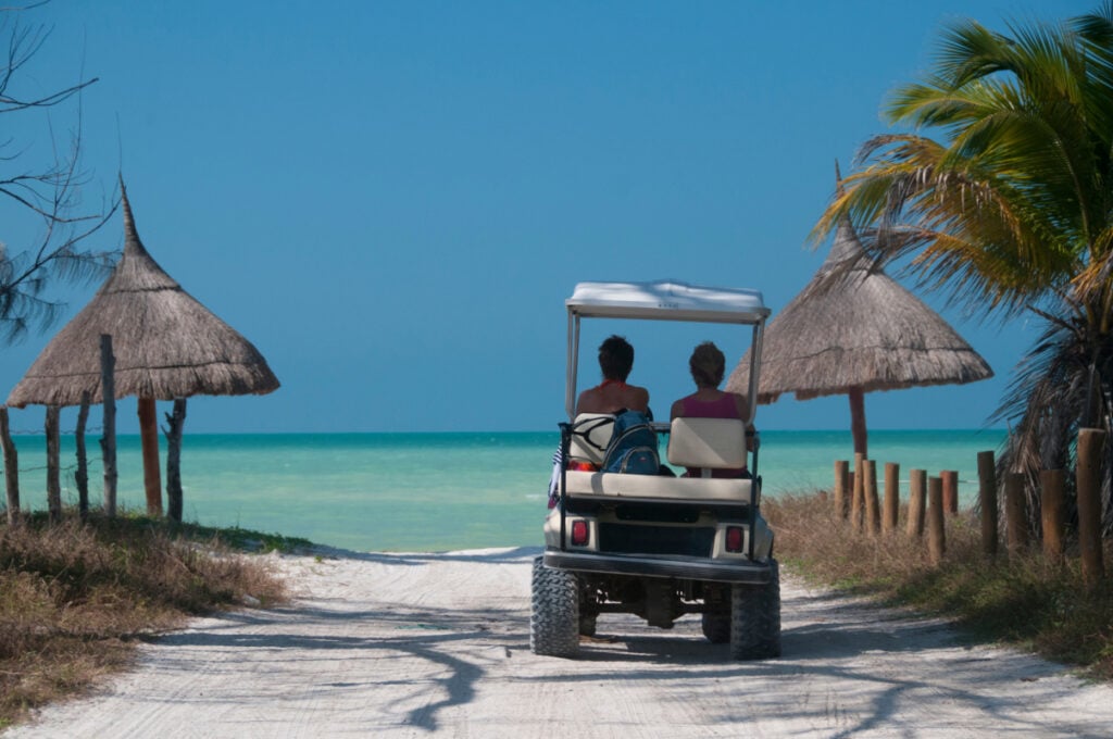 Discover the Caribbean island with a fun golf car in Mexico on the white sand paths on the sea shore, for a perfect holiday