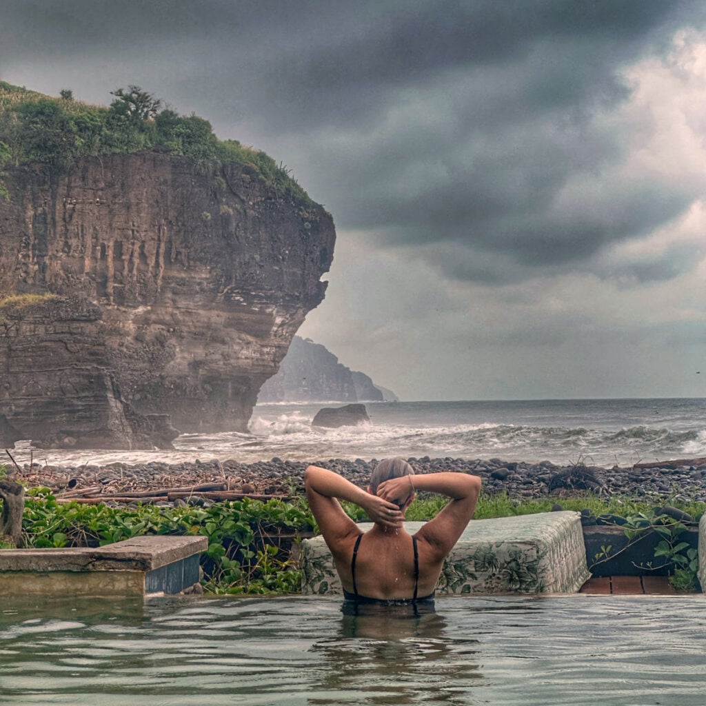 Liz Fox in El Salvador in front of dramatic cliffs and ocean. Photo by Tyler Fox