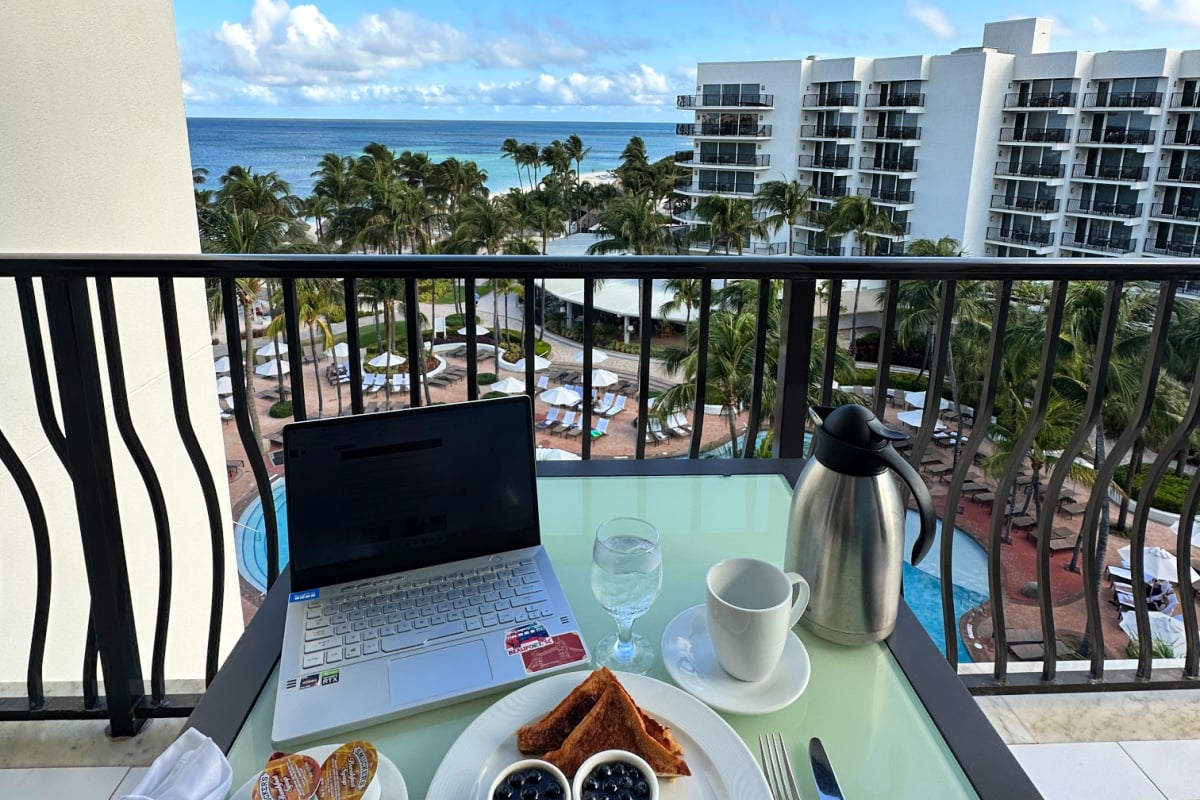 Tyler Fox working remotely at Marriott in Aruba with breakfast on balcony