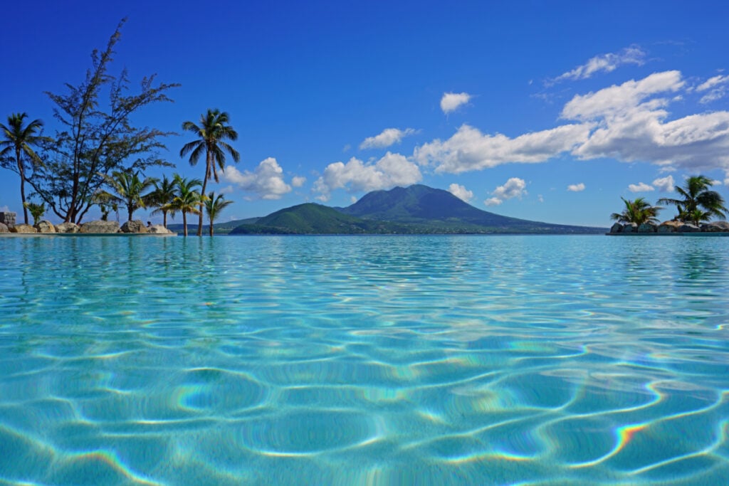 View of the Nevis Peak volcano from a swimming pool in Christopher Harbour, St Kitts