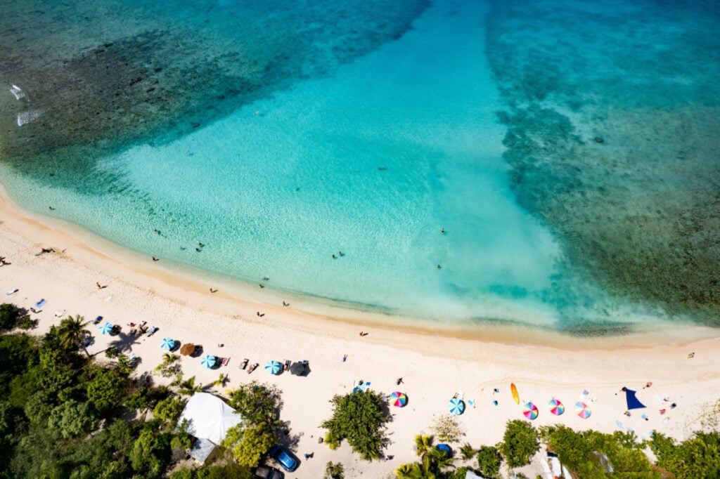 Aerial view of Smuggler's Bay beach in Tortola, British Virgin Islands, with a stunning shoreline featuring vibrant hues of blue and turquoise
