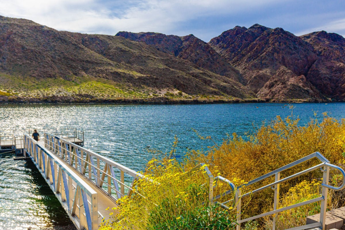 Female Tourist Walking on Fishing Pier on The Colorado River at Willow Beach Marina, Lake Mead National Recreation Area, Arizona, USA