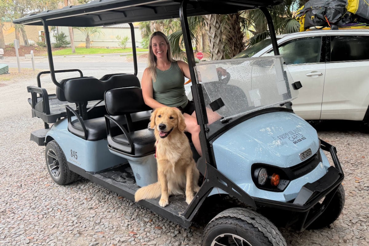 Liz Fox with golden retriever on golf cart at Fripp Island, South Carolina
