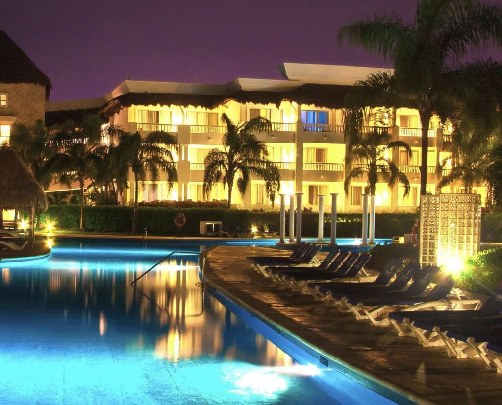 Resort at night with blinds open to room view from pool