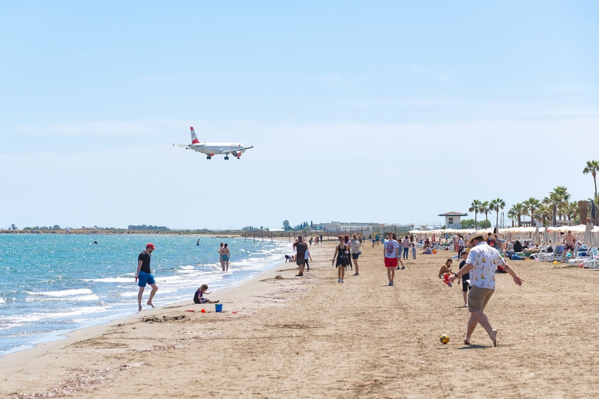 Sandy Beach With A Plane Flying Overhead, Cyprus