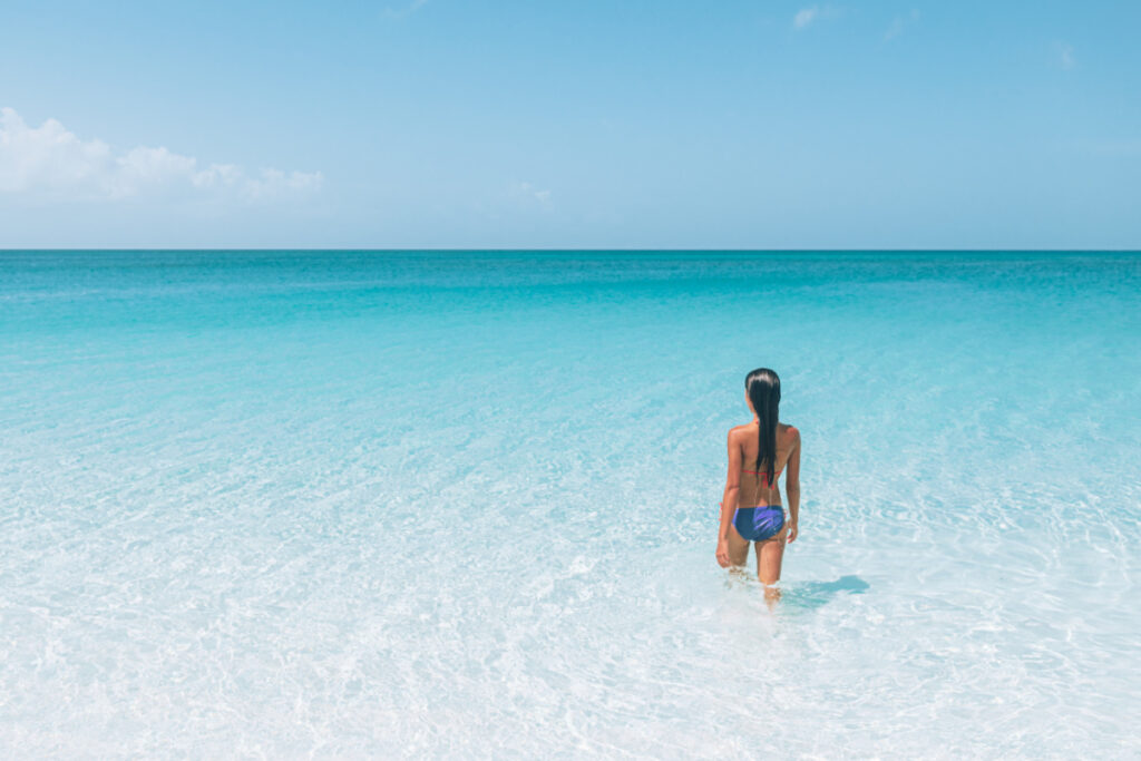 Woman walking into the ocean in South Caicos