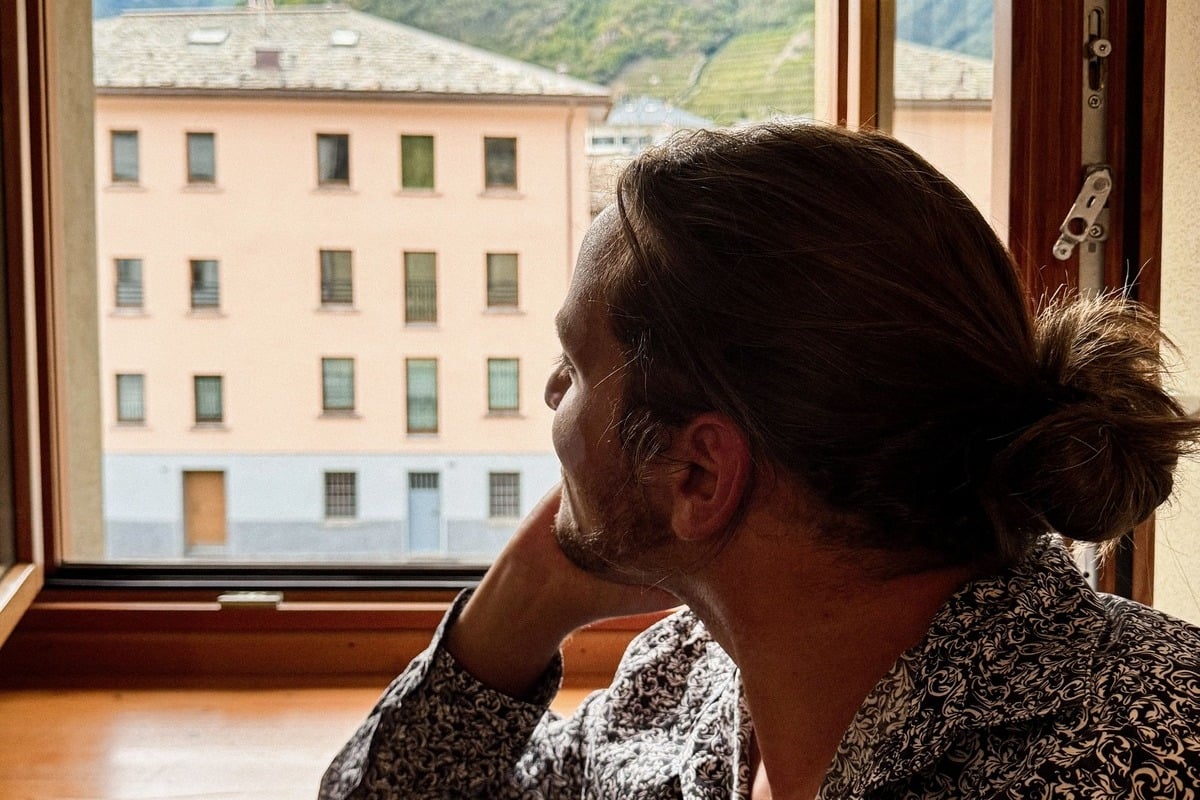 A Male Tourist Admiring A View Of Tirnao From Inside A Historic Room In A 16th Century Guesthouse Le Stanze Il Trenino Rosso, Tirano, Italy