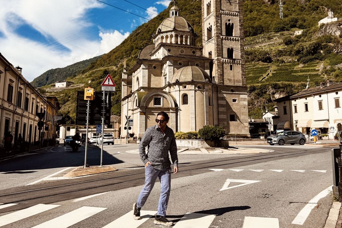 A Male Tourist Crossing A Zebra Crossing In Central Tirano, Italy
