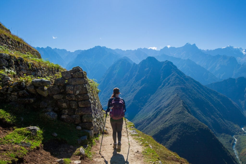 Late afternoon sun shines down on a teenage girl hiking the Inca Trail to Machu Picchu