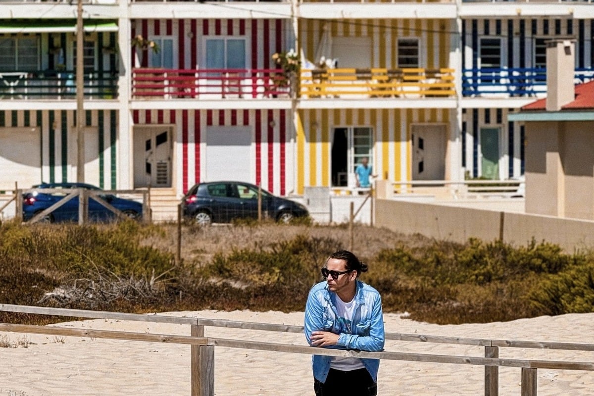 Male Tourist In Front Of Colorful Houses In Costa Nova, Portugal