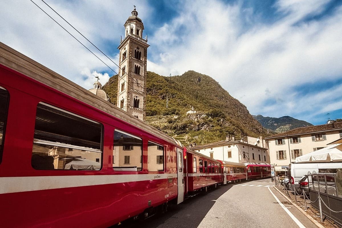 The Red Train Passing Through Tirano, Italy On The Way To Switzerland