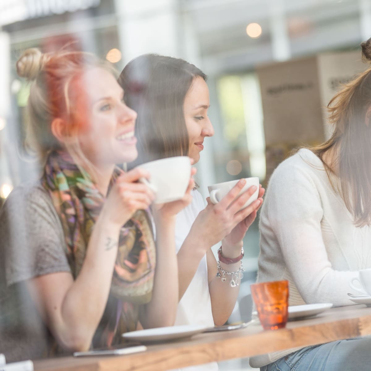 A Trio Of Female Friends Enjoying Coffee In A Copenhagen Cafe, Denmark