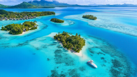 Aerial view of a tropical lagoon with turquoise water and small islands in Bora Bora, French Polynesia. featured
