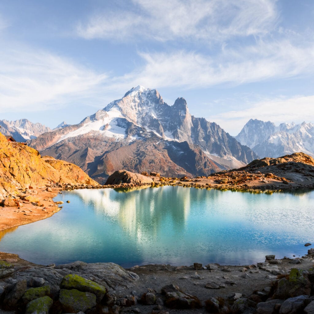 Crystal-clear Lac Blanc reflects sky and Mont Blanc range in French Alps near Chamonix. Peaceful alpine lake view with stunning mountain mirror and serene landscape