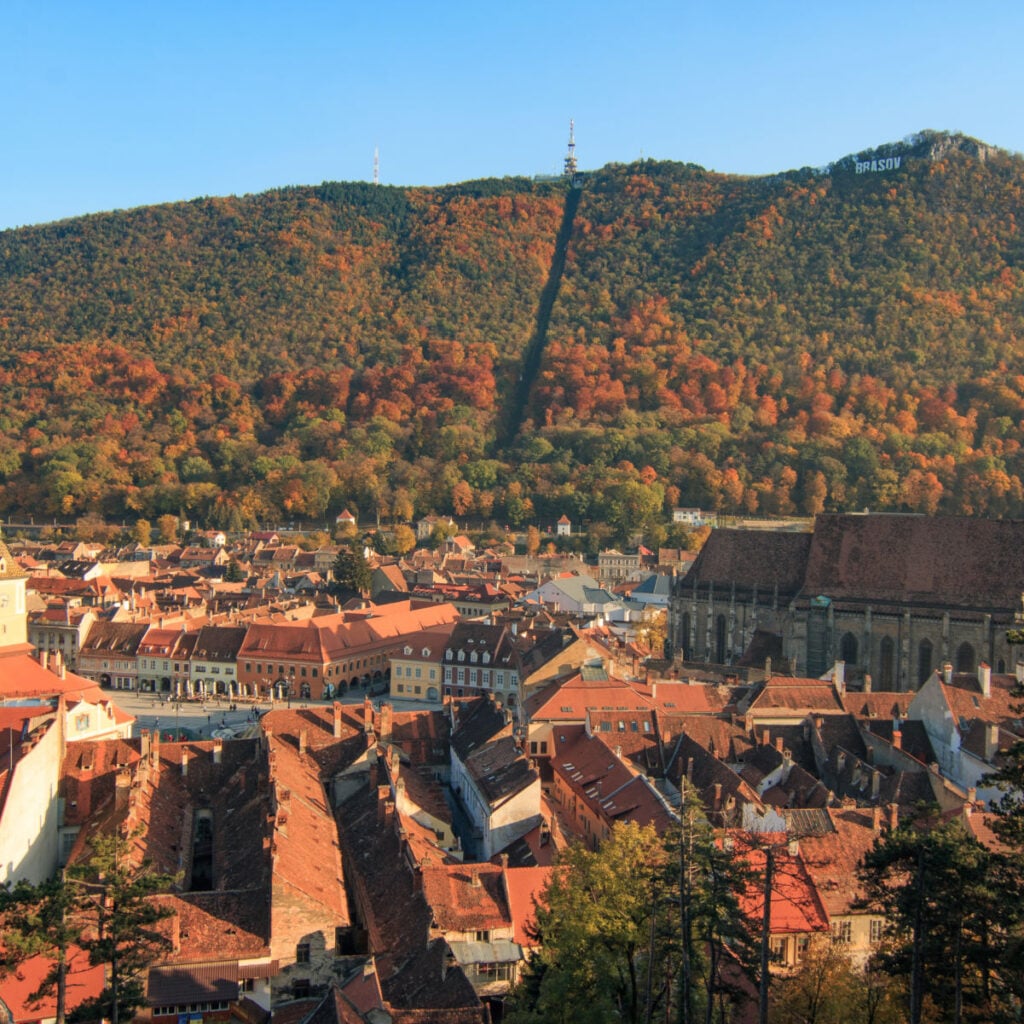 Europe, Romania, Brasov. City signage. Poarta Schei district. Looking out over forested park and hill side near the Tampa Mountain area.