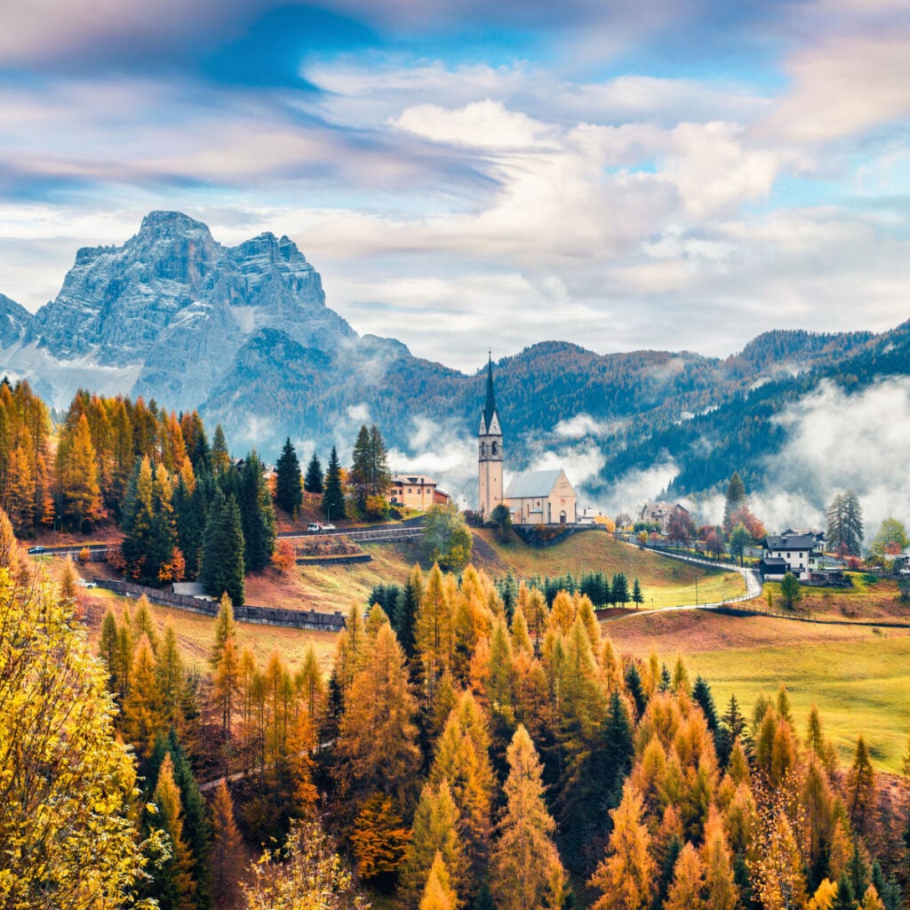 Foggy autumn view of Parrocchia Di Selva Cadore church. Great morning scene of Dolomite Alps, Cortina d'Ampezzo, southern Alps in the Veneto region of Northern Italy, Europe.